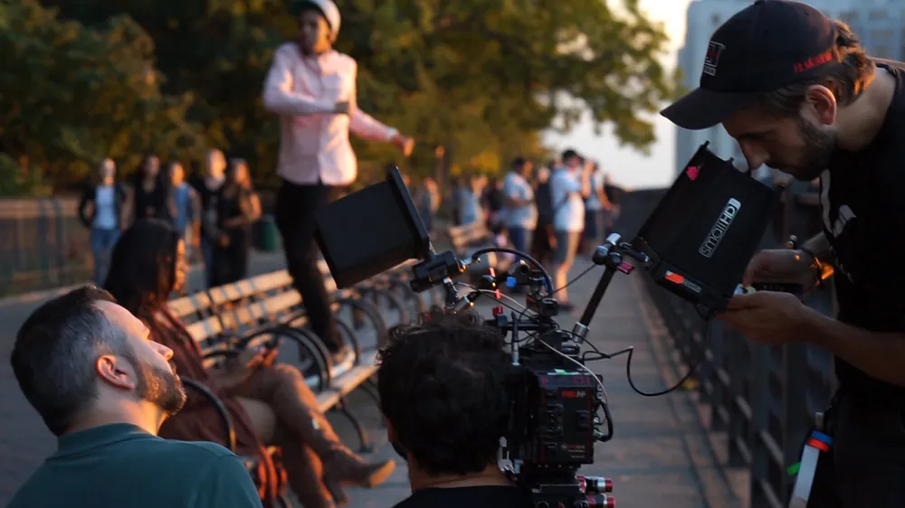 Crew filming on a waterfront at golden hour