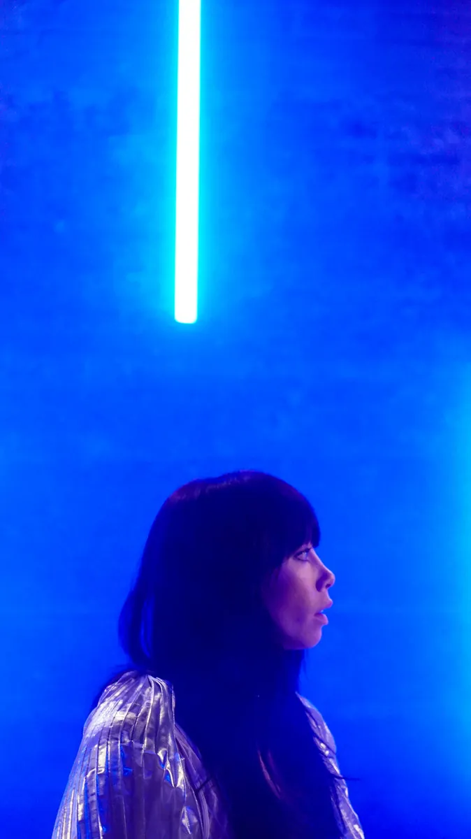 Singer lit by a blue light tube