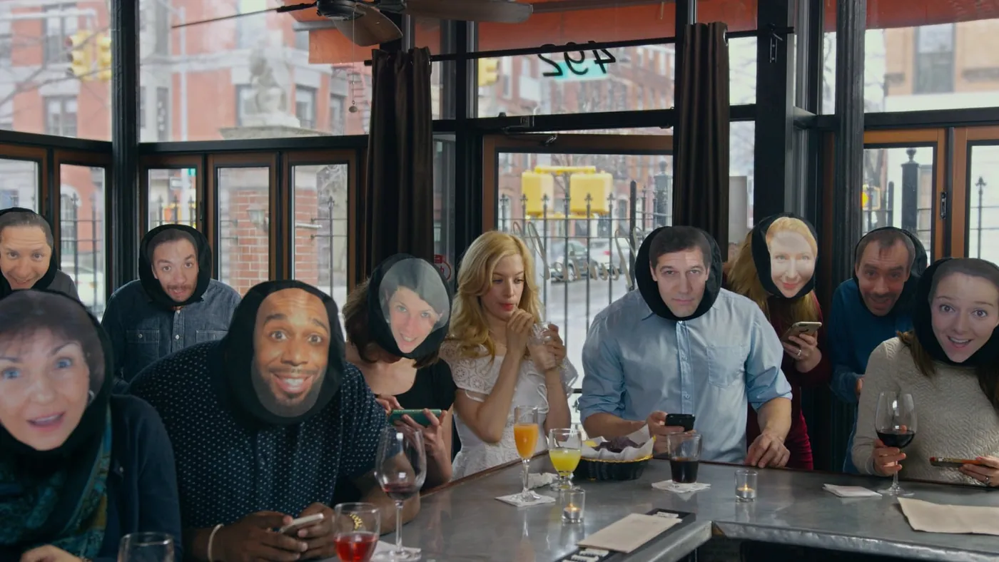 Cast wearing printed face masks at a restaurant table